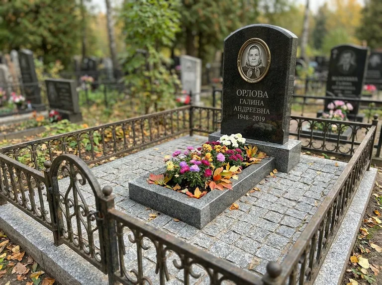 Благоустроенное захоронение с гранитной плиткой, оградой и цветником в Белгороде