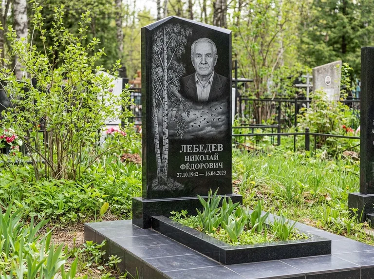 Памятник с гравировкой берёзы: вертикальная стела со скошенным верхом — берёза и стая птиц в небе, гранитный цоколь с тёмной плиткой, работа «Лебедев» в Белгороде