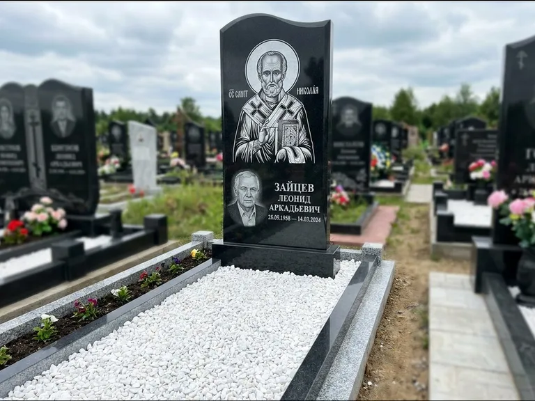 Памятник с гравировкой иконы: стела с крестообразным навершием — икона в резной рамке-киоте, газон без ограды, стриженая трава, работа «Раевская» в Белгороде