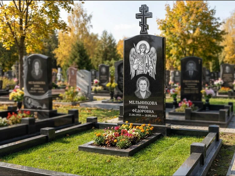 Памятник с гравировкой иконы: округлая стела-медальон с ликом — гравировка Богородицы «Семистрельная», луговые травы и полевые цветы за участком, работа «Гущин» в Белгороде